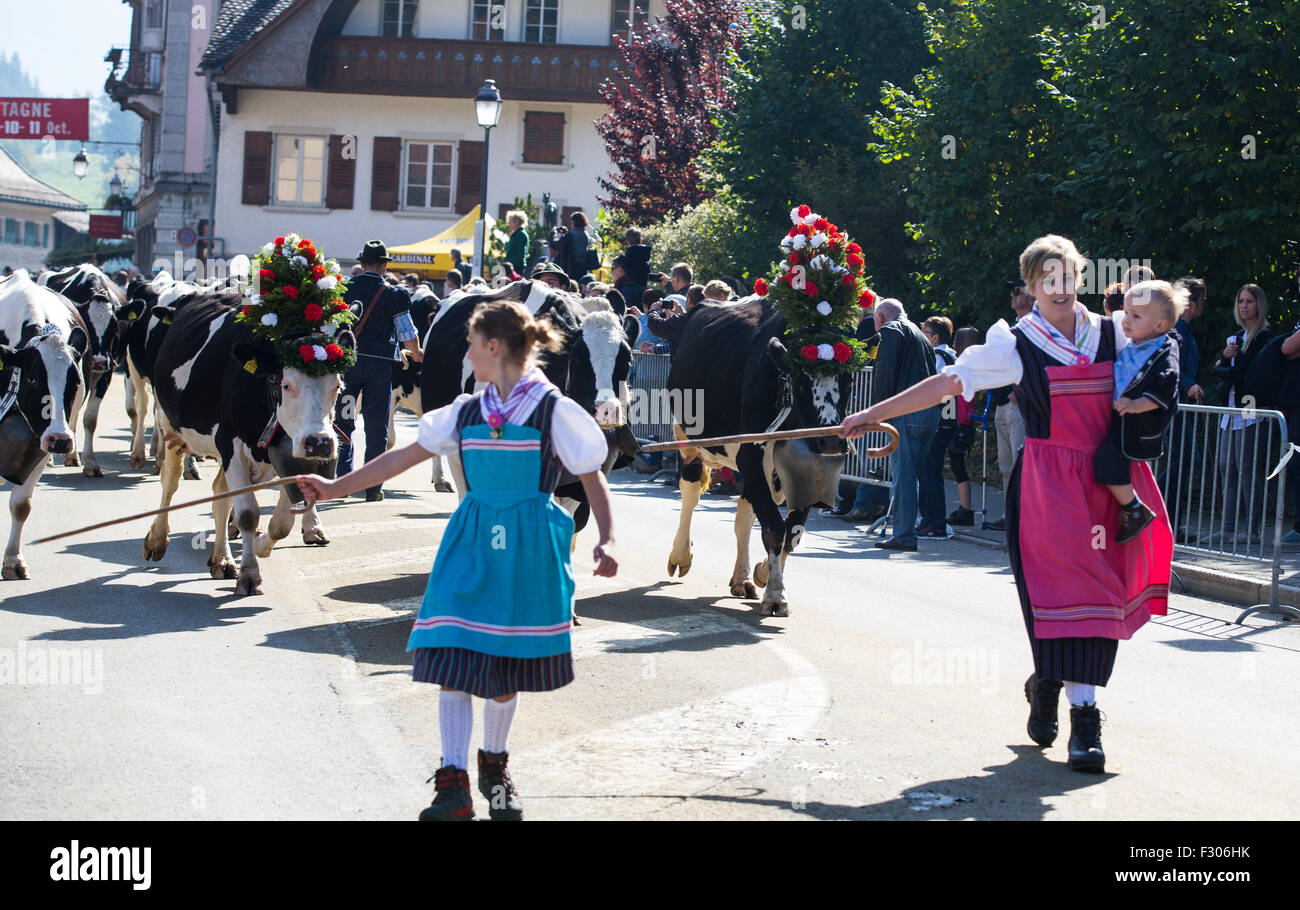 Geneva, Switzerland. 26th Sep, 2015. A local herdswoman and her children in traditional dress drive their cows down the mountains during the Desalpe festival in Charmey, Switzerland, Sept. 26, 2015. The Desalpe is a traditional annual procession when cows make their way down to the plain at the beginning of the Autumn after more than four months of grazing on the Alpine pastures during the Summer. © Xu Jinquan/Xinhua/Alamy Live News Stock Photo