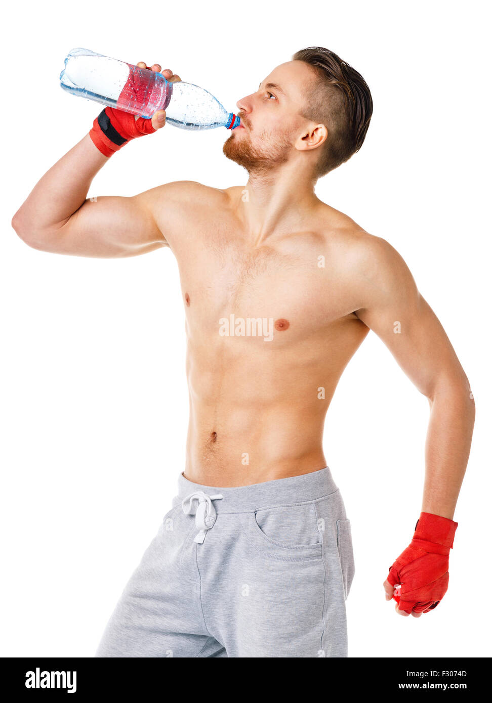 Sport attractive man wearing boxing bandages and drinking fresh water on the white background Stock Photo