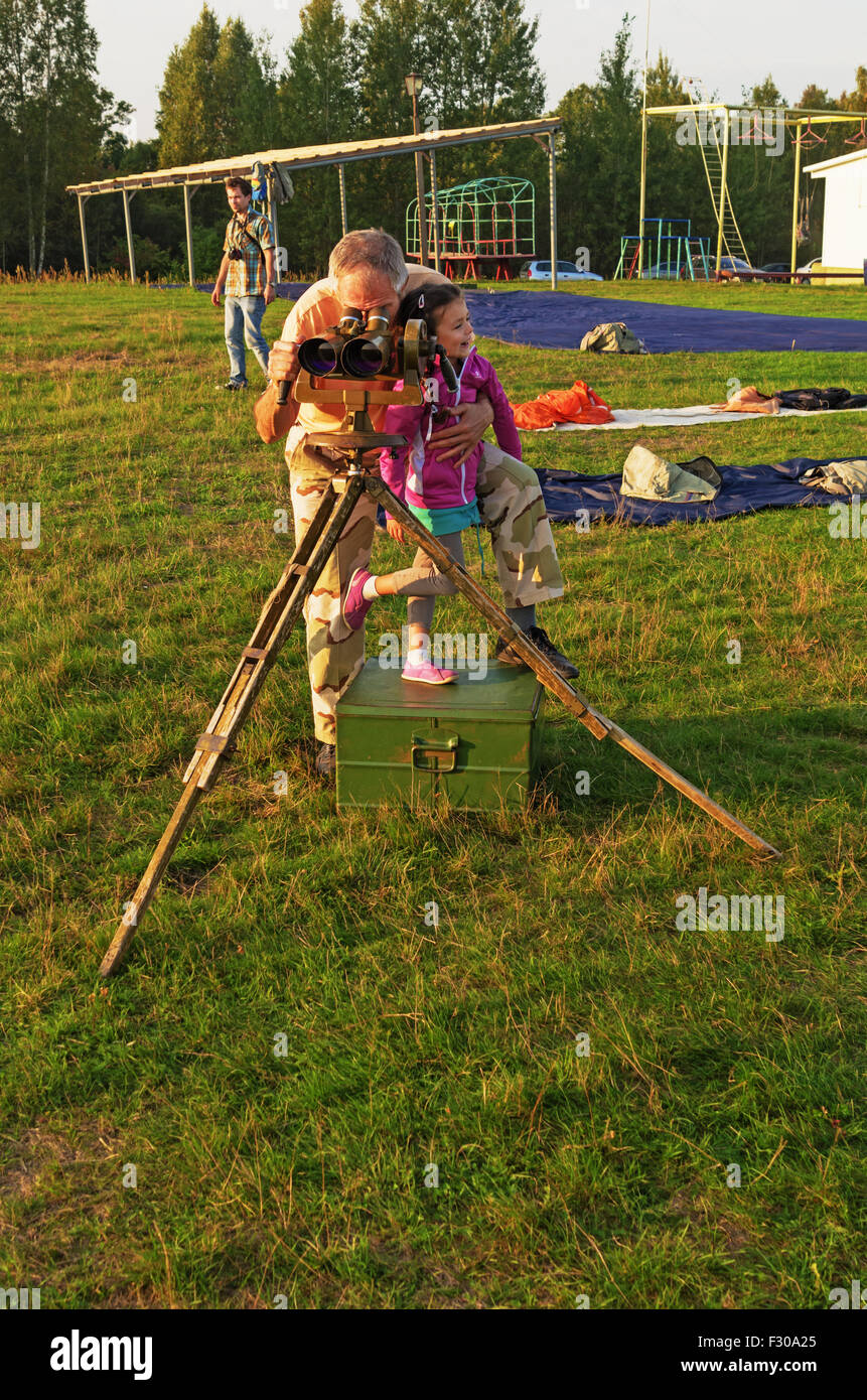 Parachutists - 2014. Looking to sky. Grandfather, girl and field-glass. Stock Photo
