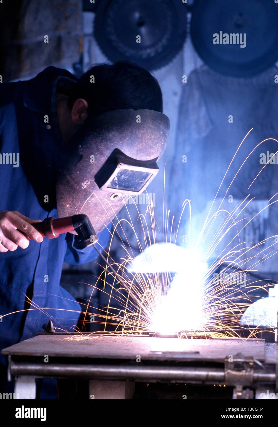 Man welding wearing protective clothing in a workshop., England, UK, Western Europe. Stock Photo