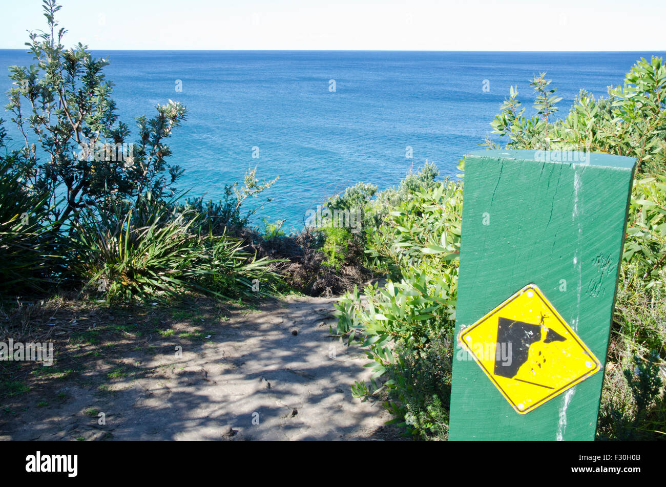 Warning sign, crumbling cliff edge.North Narrabeen Headland, NSW Australia Stock Photo
