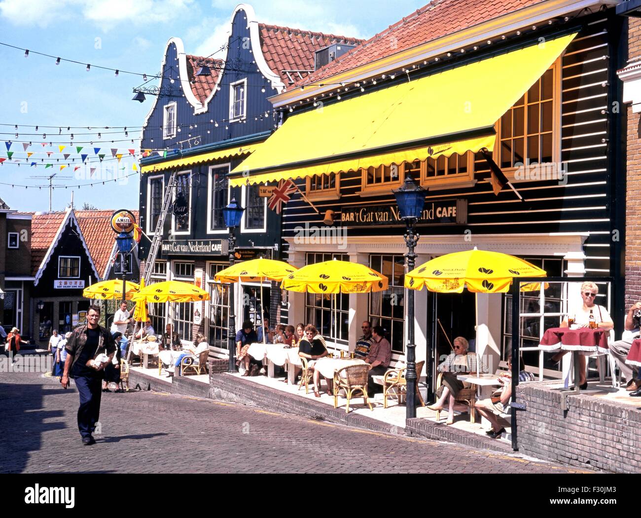 People relaxing at pavement cafes during the Summertime, Volendam, Holland, Netherlands, Europe. Stock Photo
