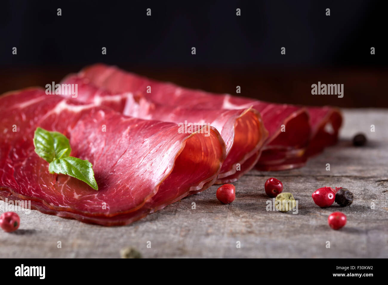 Smoked beef meat slices over rustic background Stock Photo