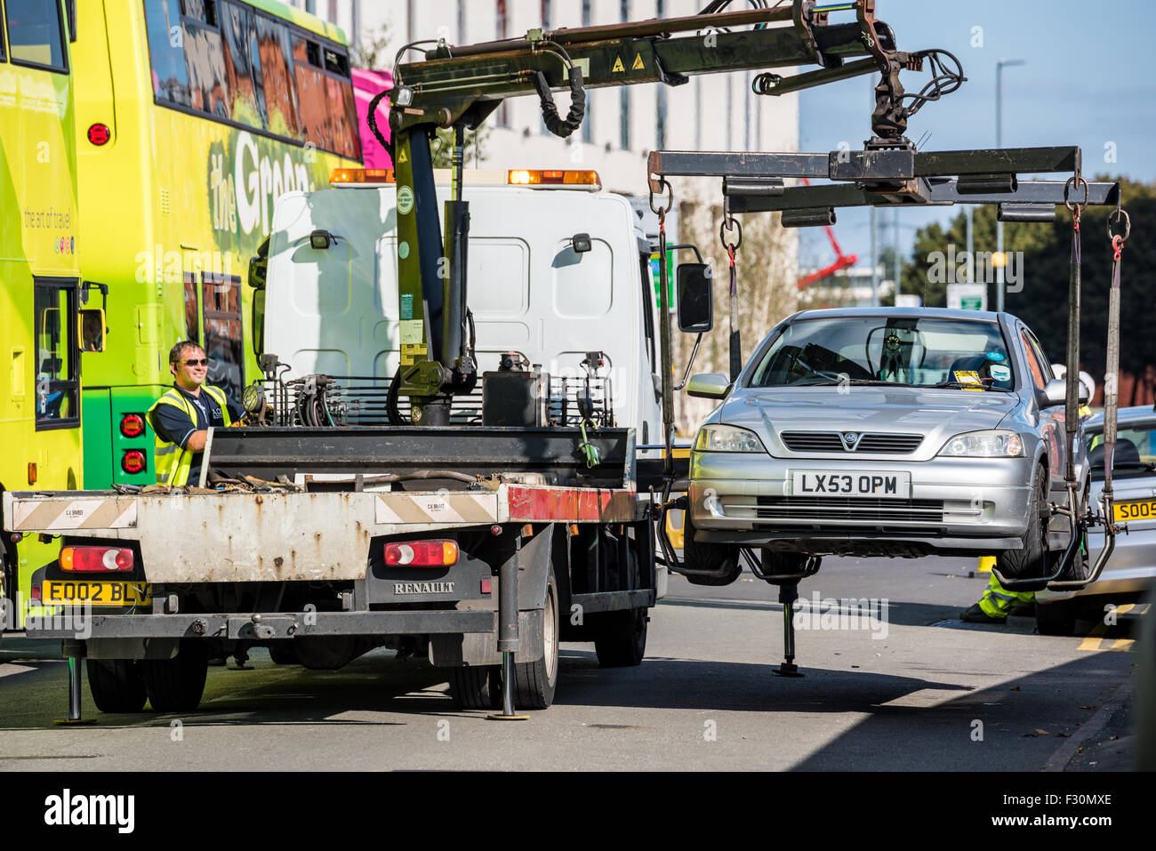 A Car being lifted and taken away on the back of a pickup truck  for illegal parking in Birmingham West Midlands UK Stock Photo