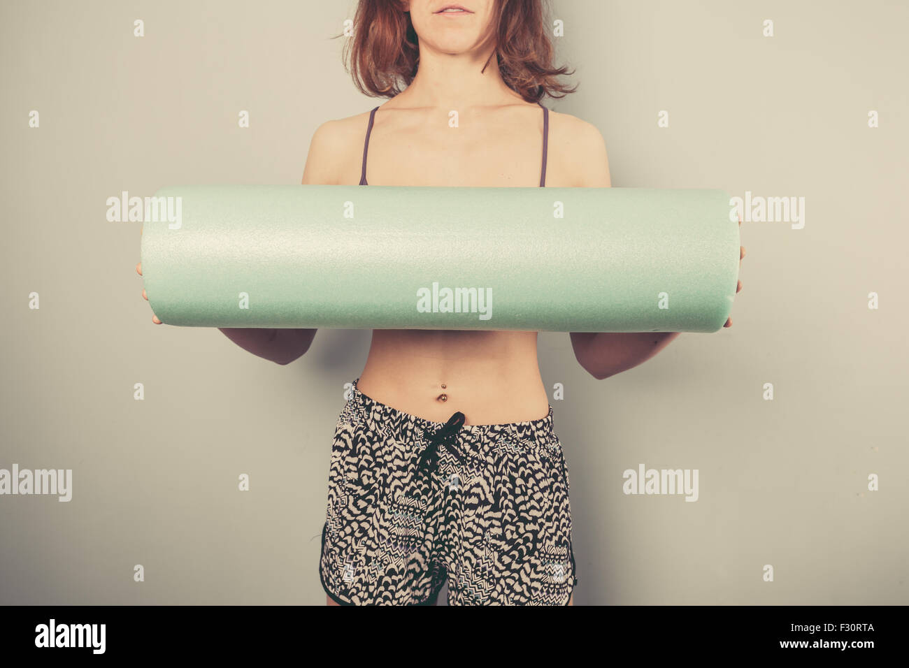 Athletic young woman is holding a foam roller for exercise Stock Photo ...