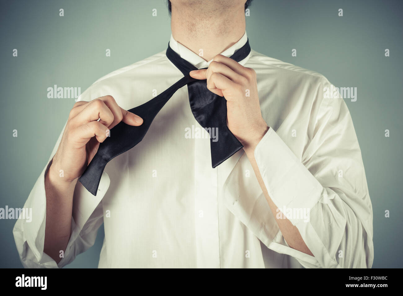 Young man is showing how to tie a formal bow tie Stock Photo Alamy