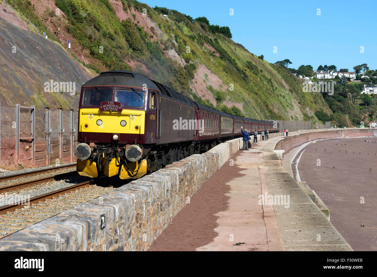 Class 47 diesel locomotive 47760 hauls The Cathedrals Express past the sea wall Teignmouth south Devon UK Stock Photo