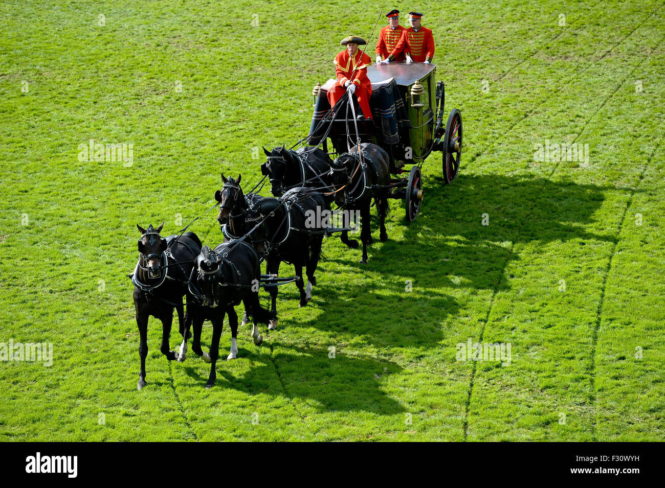 Coachmen sit on a historic horse drawn carriage with six horses