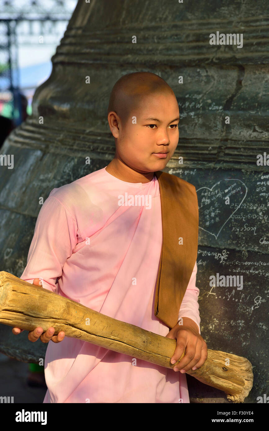 A Novice nun ringing the great bell of Mingun , Sagaing Region, Myanmar.Burma Stock Photo