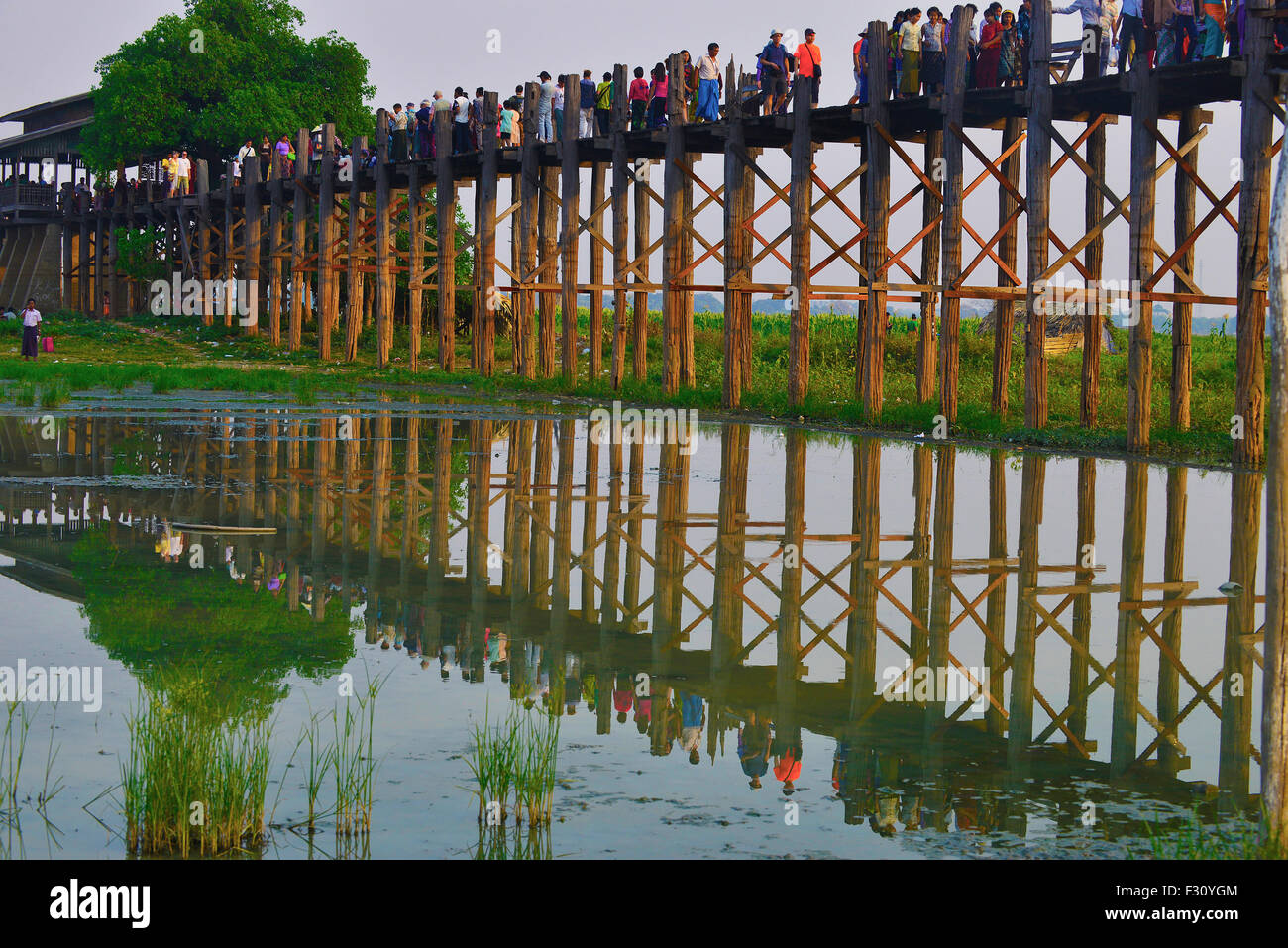 Sightseers and tourists crossing the famous 1.2km U Bein wooden bridge which spans the Taungthaman Lake near Amarapura,Myanmar,(Burma), Southeast Asia Stock Photo