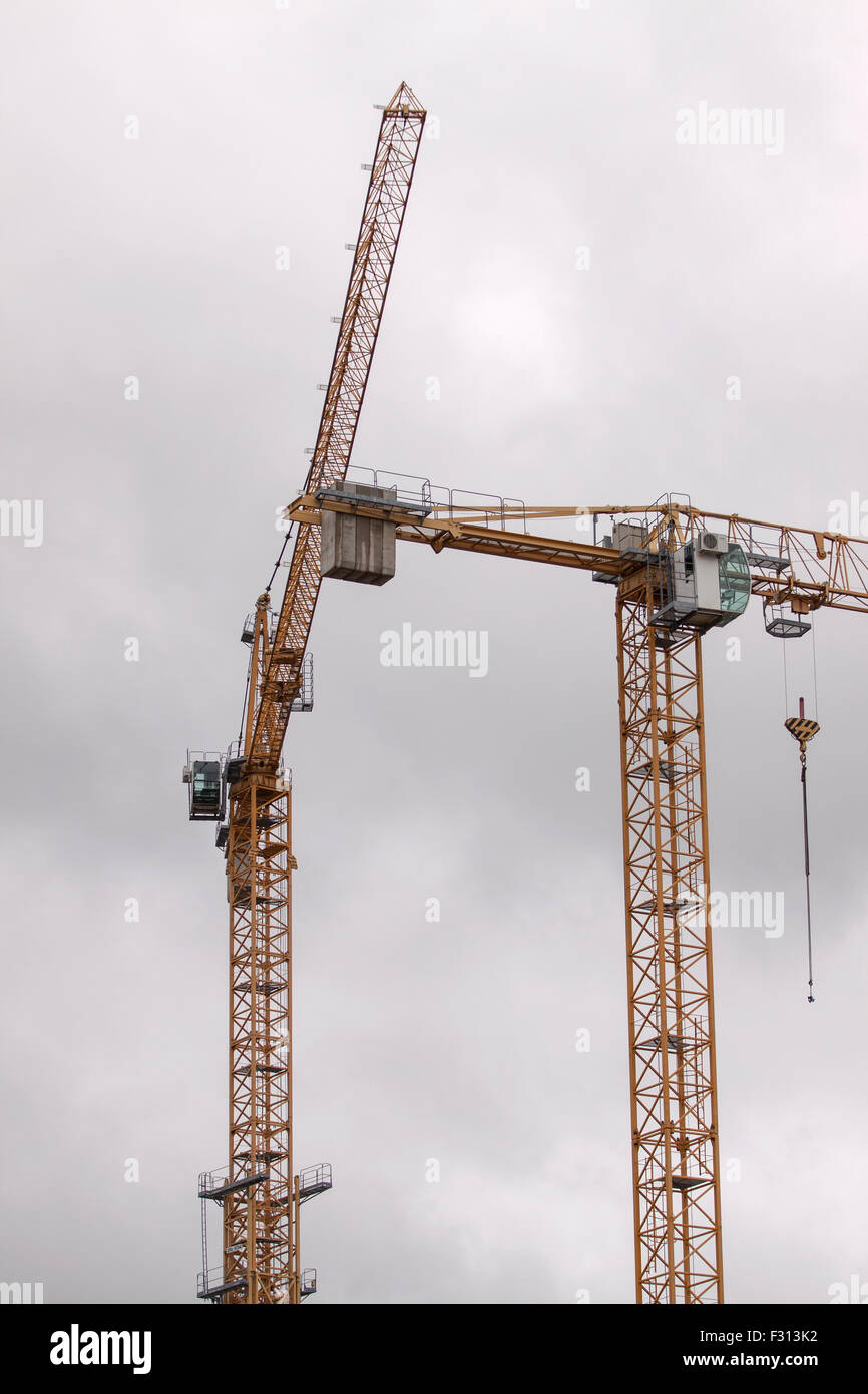 2 tower yellow cranes on a white sky background Stock Photo - Alamy