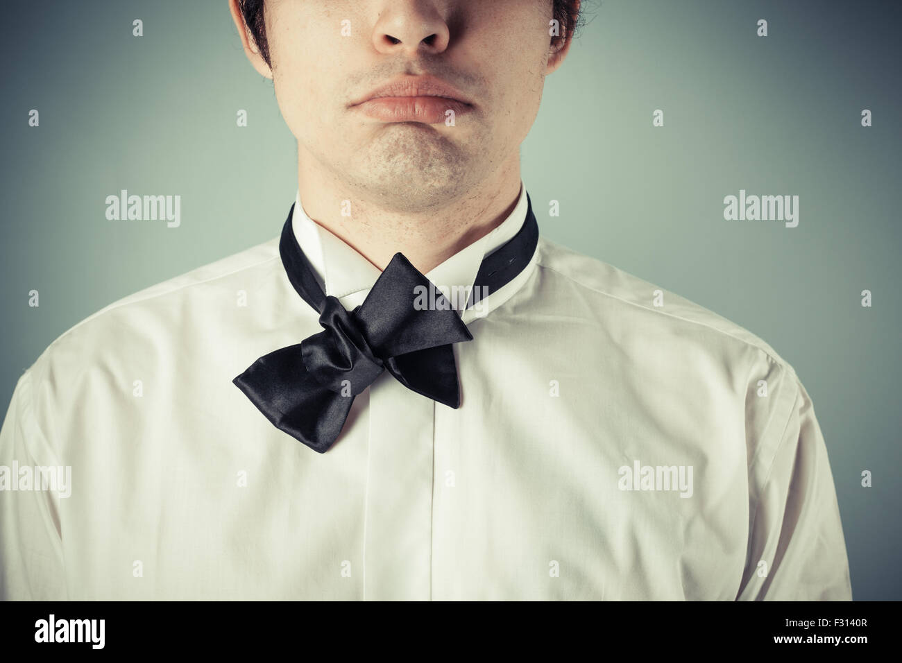 Young man does not know how to tie a bow tie Stock Photo