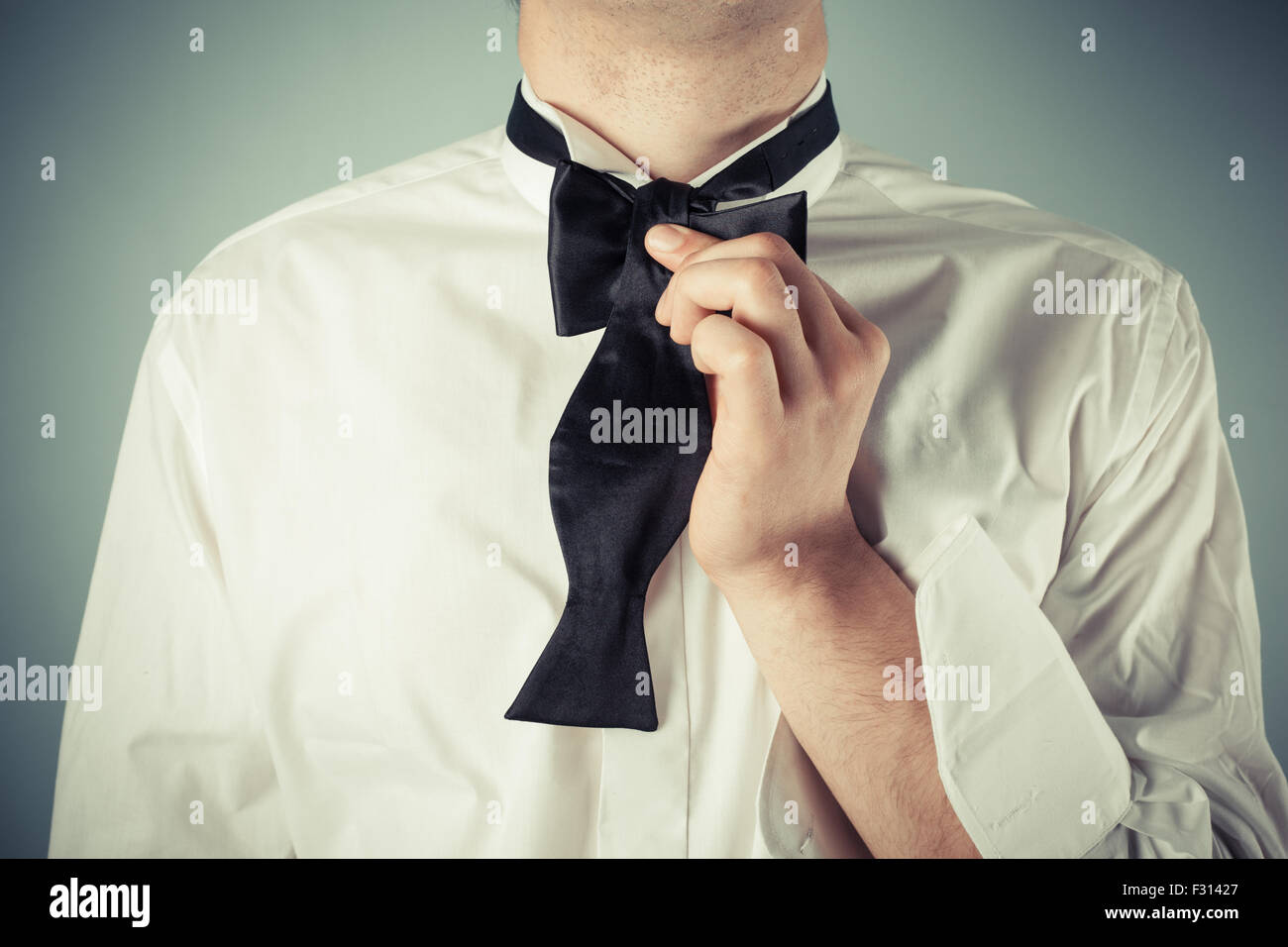 Image showcasing Young man is showing how to tie a formal bow tie Stock Photo - Alamy