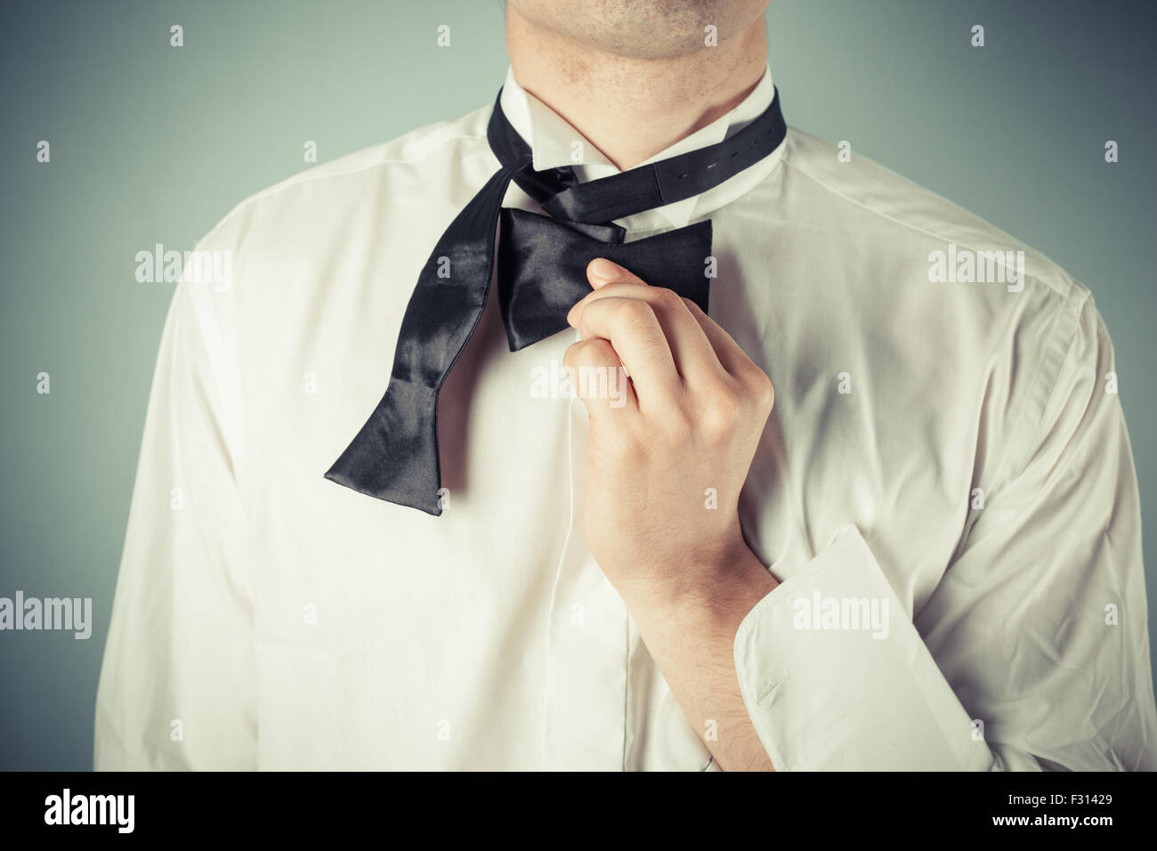 Young man is showing how to tie a formal bow tie Stock Photo Alamy