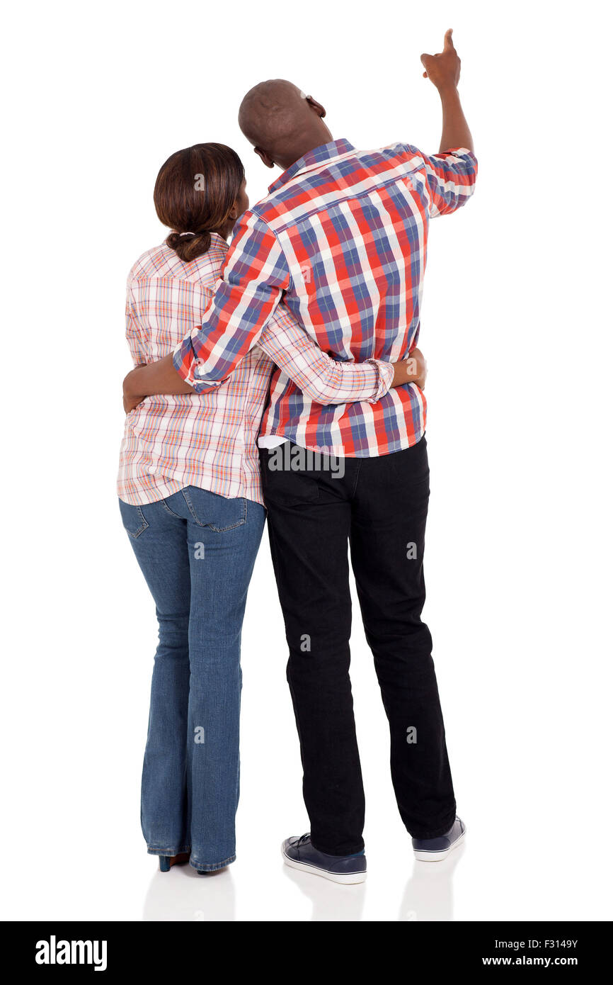 rear view of young African couple pointing isolated on white background ...