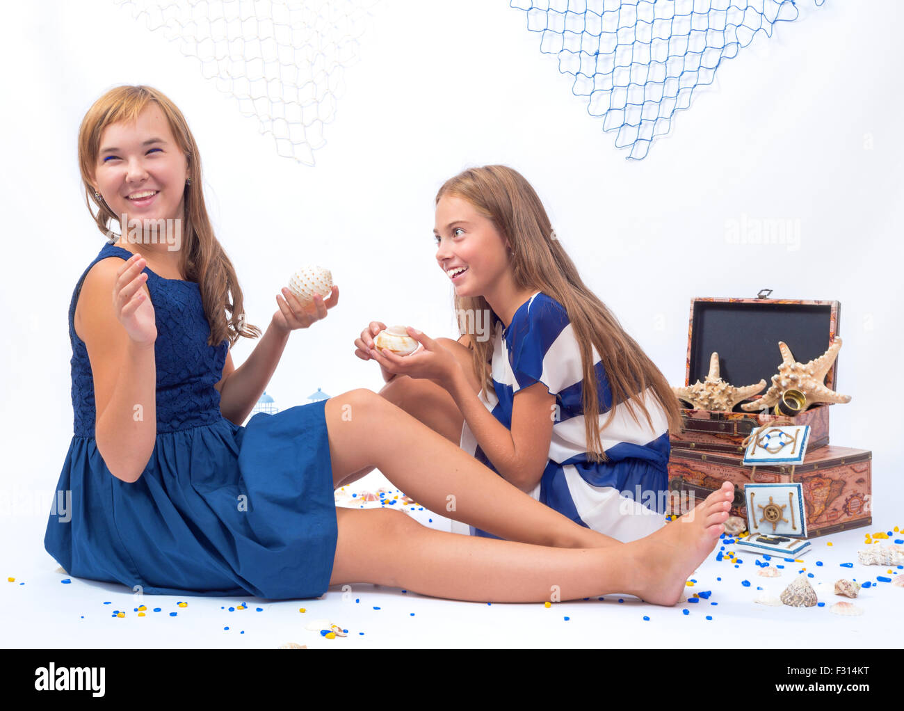 Two beautiful teen girls laughing sitting on the floor Stock Photo - Alamy