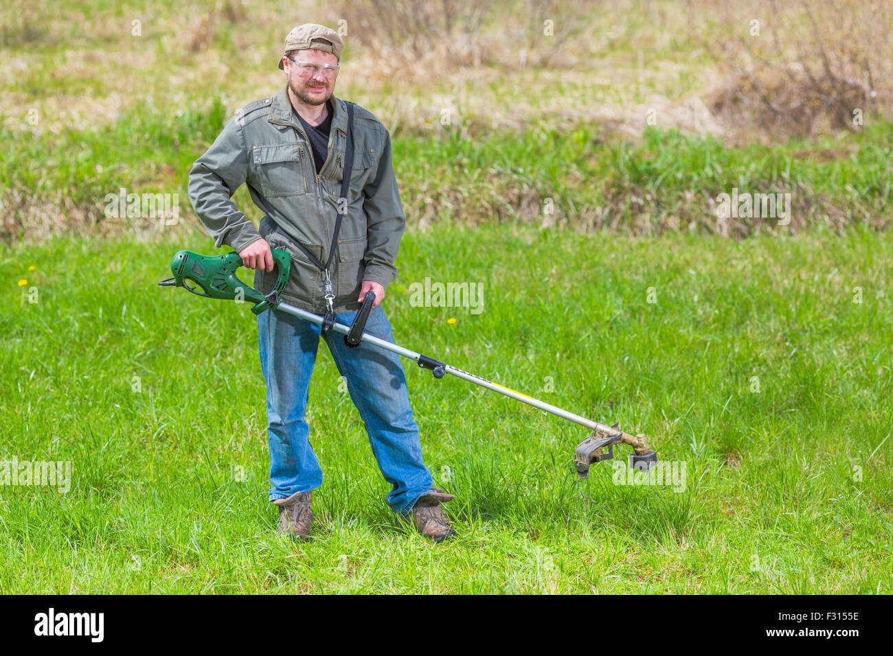 Lawnmower man green field cultivating rural country Stock Photo