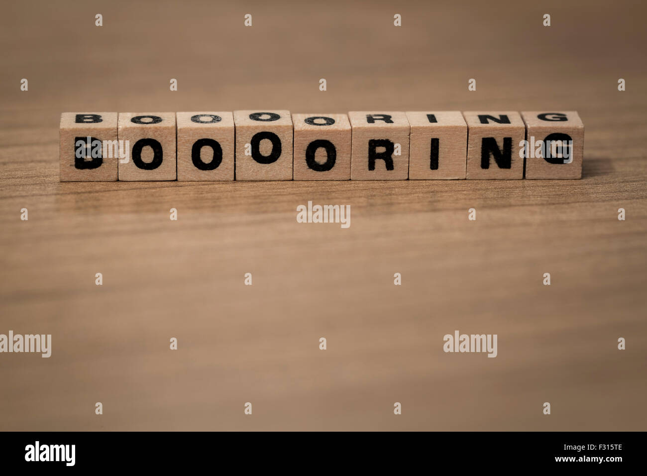 Booooring written in wooden cubes on a desk Stock Photo