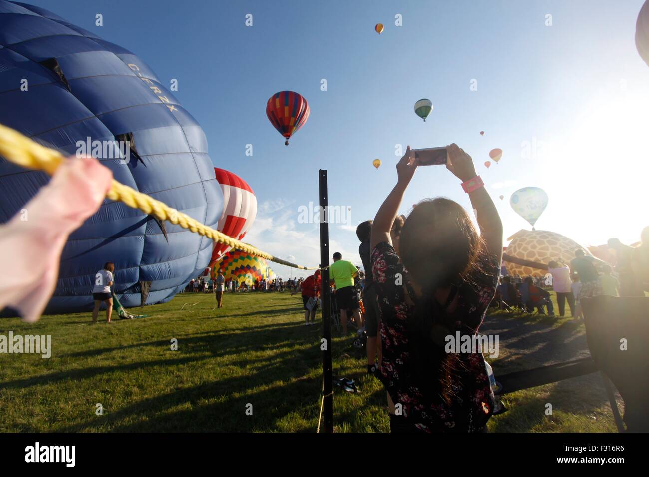 Young girl takes photo of hot air balloons at the International Balloon