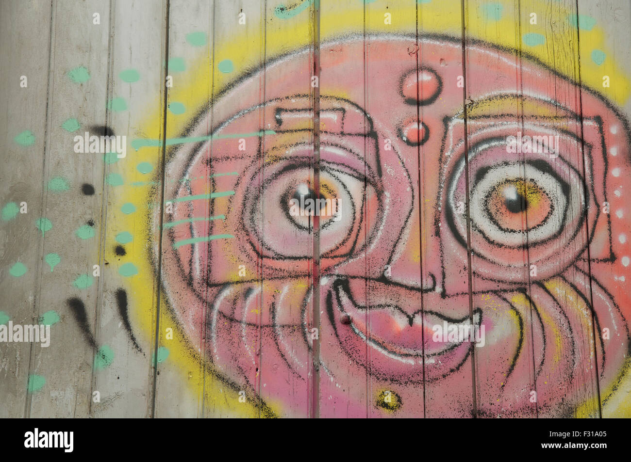 Detail of street art. Colourful graffiti of a sunny smiling face painted on a window shutter by the artist known as Loko. Montpellier, South of France. Stock Photo