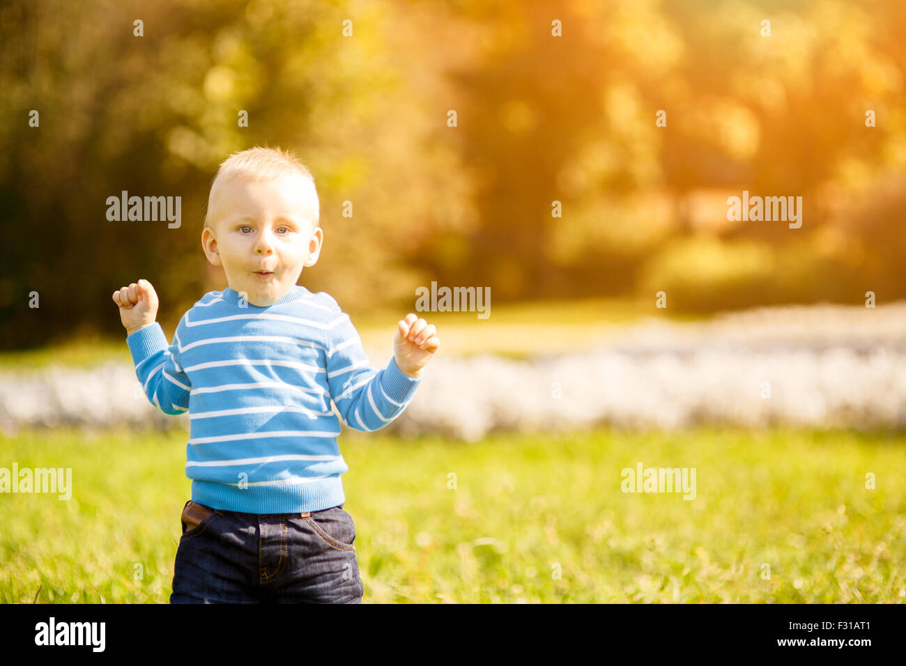 cute little boy standing in green grass in park Stock Photo - Alamy