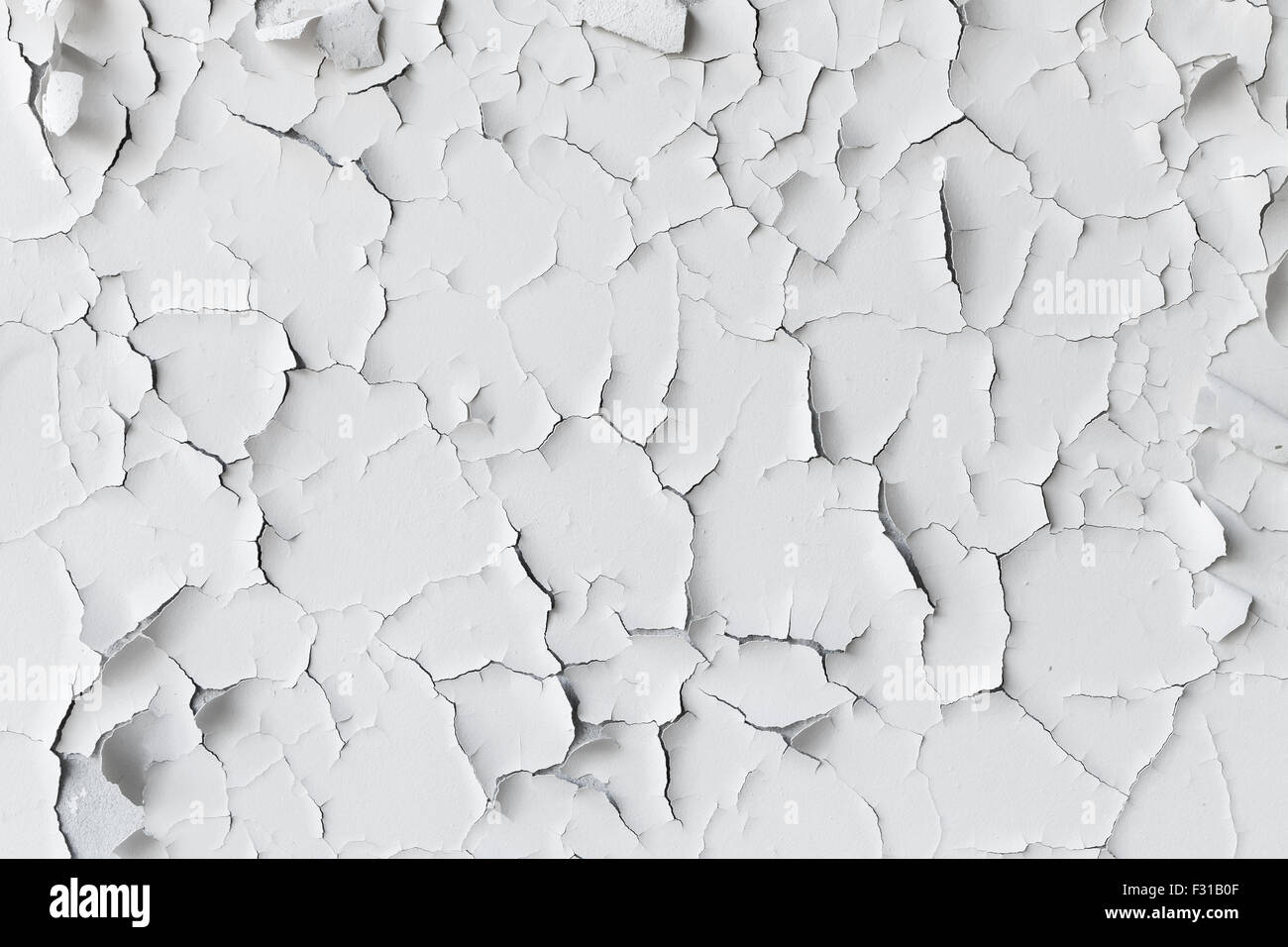 Cracked flaking white paint on the wall, background texture Stock Photo