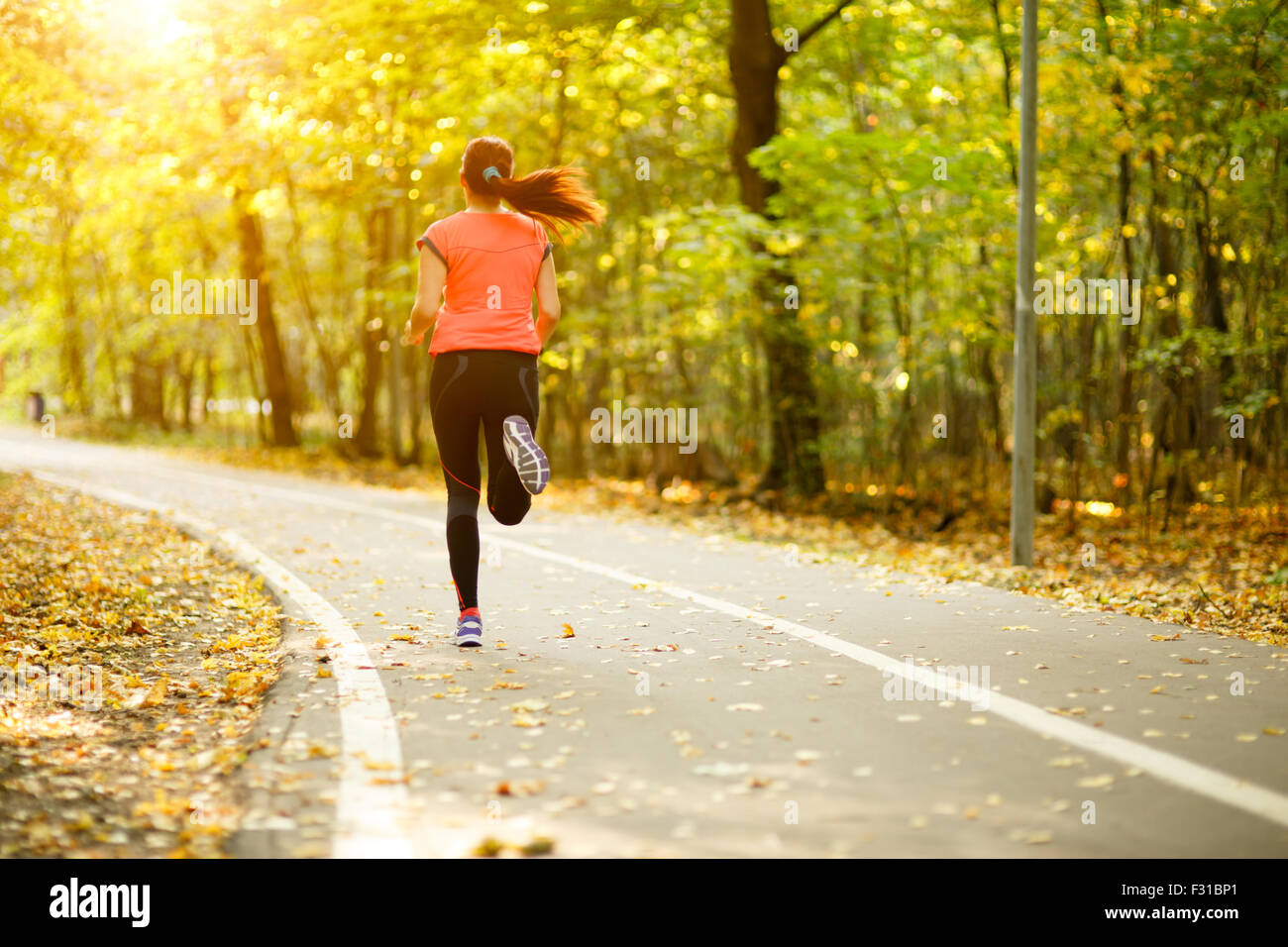 young fitness woman running at forest trail in park Stock Photo - Alamy