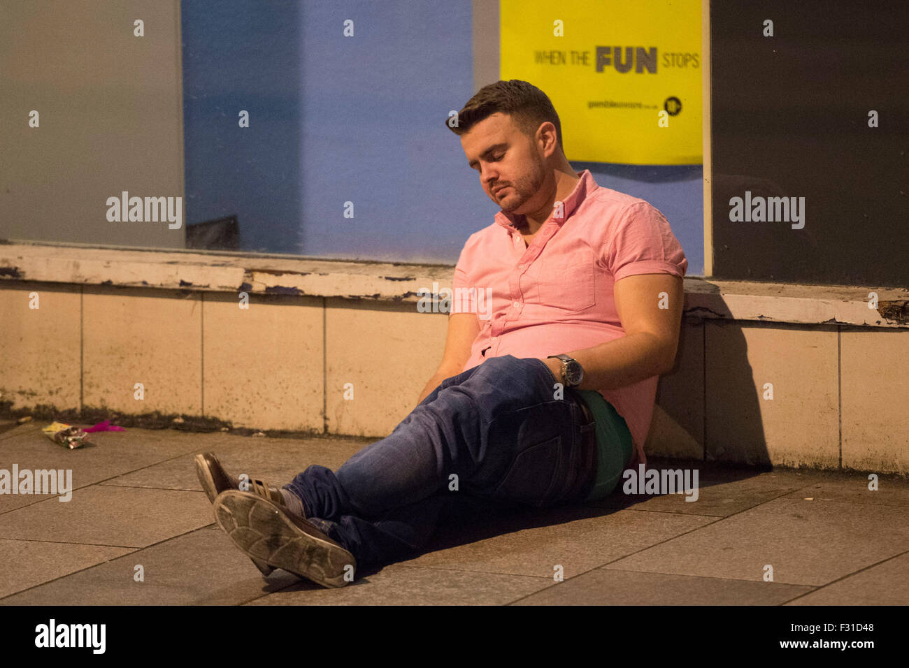 A drunk man collapsed after drinking too much alcohol. Stock Photo