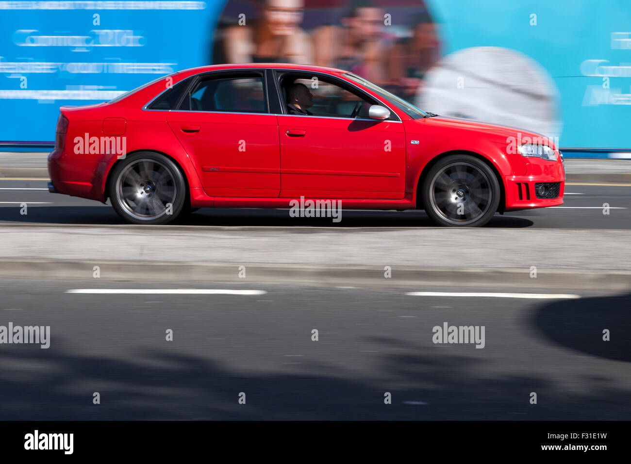 A blurred moving Audi RS4 at speed motion blur on 'The Strand' at Liverpool One, Liverpool, Merseyside, UK Stock Photo