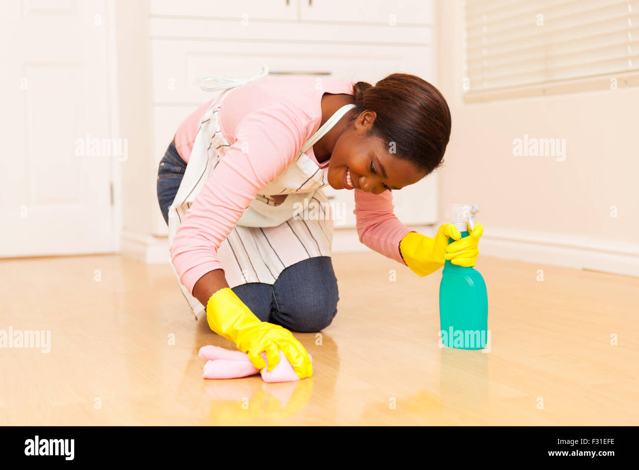 happy young African woman wiping wooden floor Stock Photo Alamy