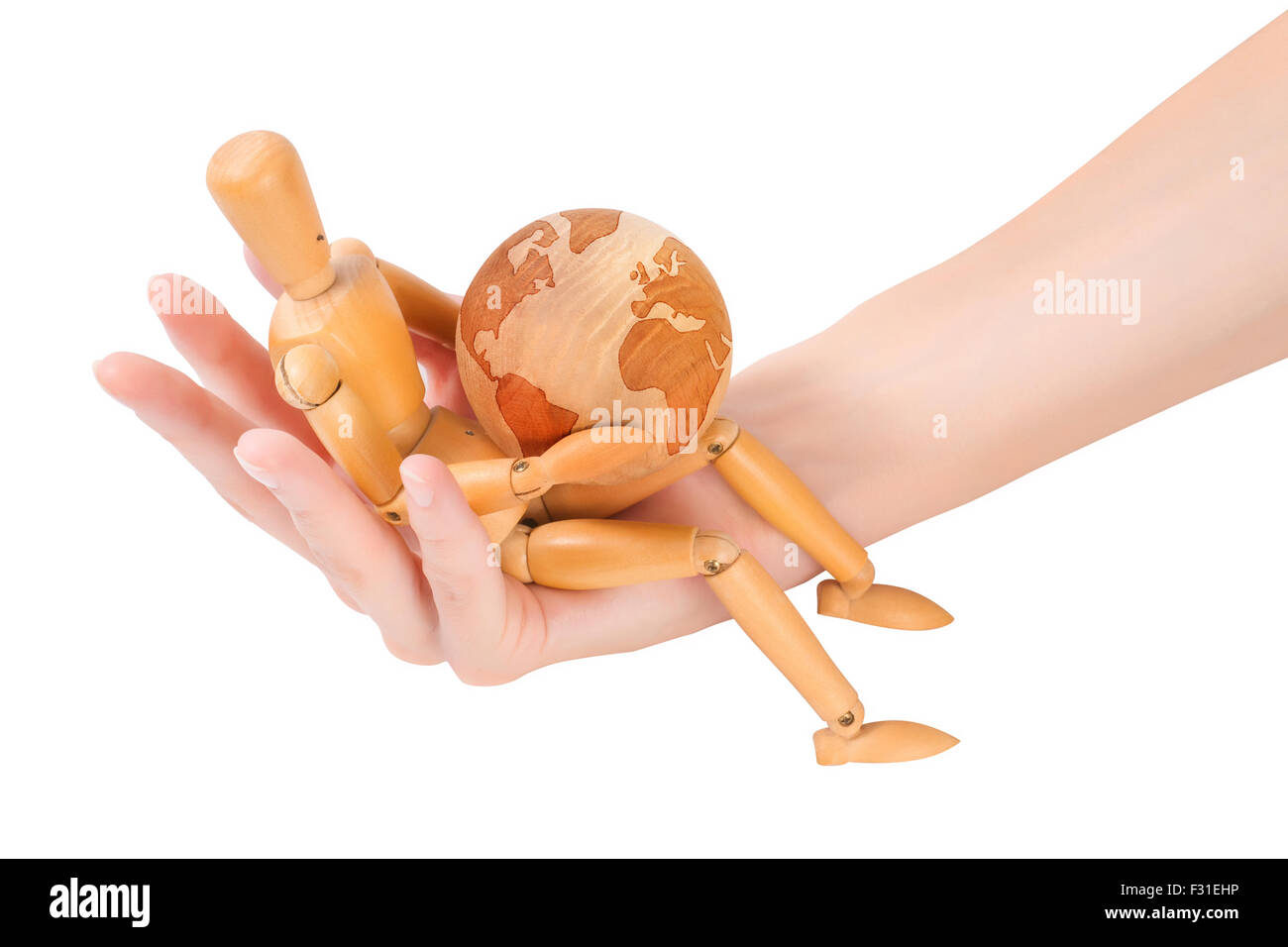 beautiful female hand holding a wooden dummy holding a wooden globe isolated on white with clipping path. concept Stock Photo