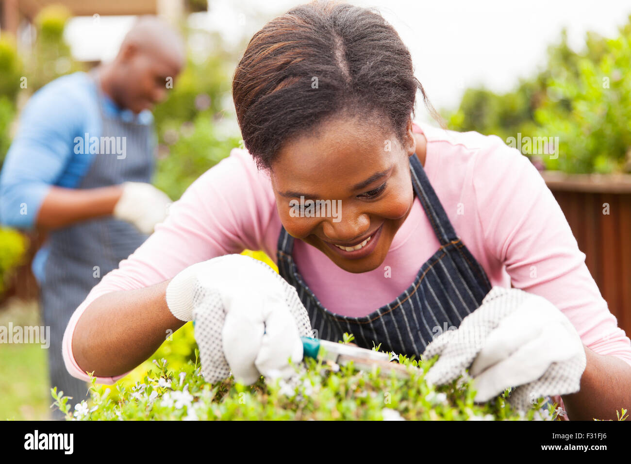 pretty African woman gardening at home Stock Photo