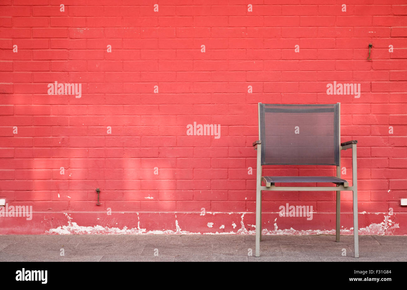 Chair and lamp against brick wall Stock Photo