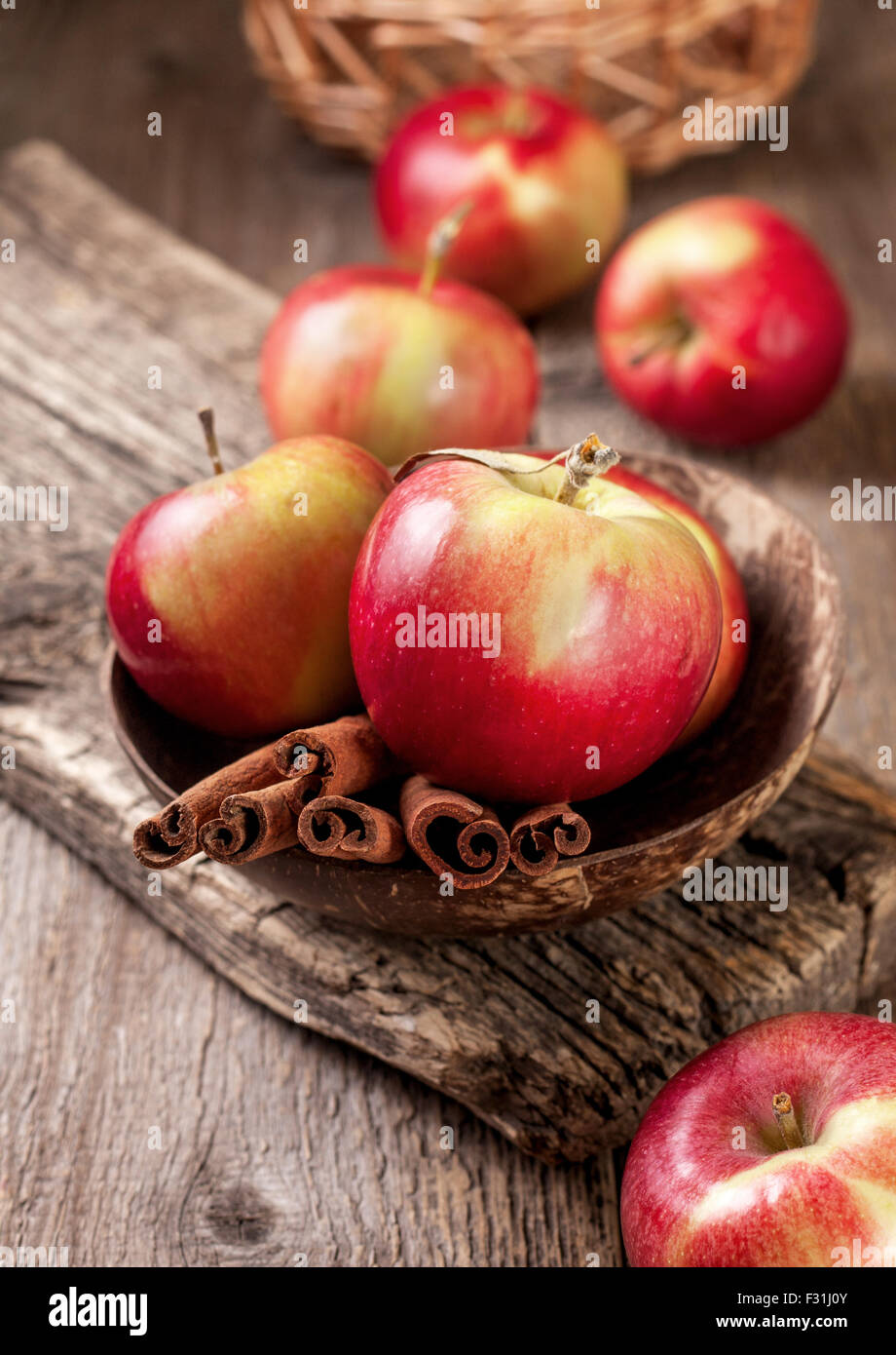 cinnamon sticks and apples on the old wooden background Stock Photo