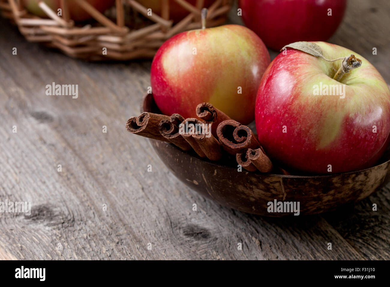 cinnamon sticks and apples on the old wooden background Stock Photo