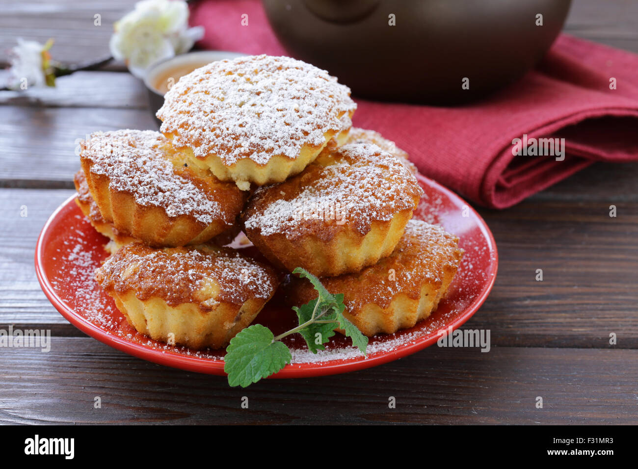 mini madeleine muffins with powdered sugar on a red plate Stock Photo Alamy