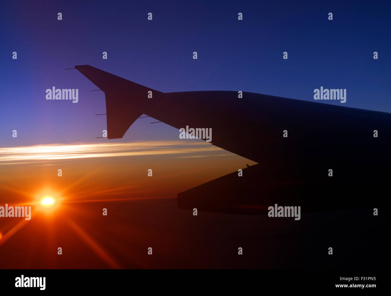 Wing of Aeroplane at sunset, Atlantic Ocean. Stock Photo