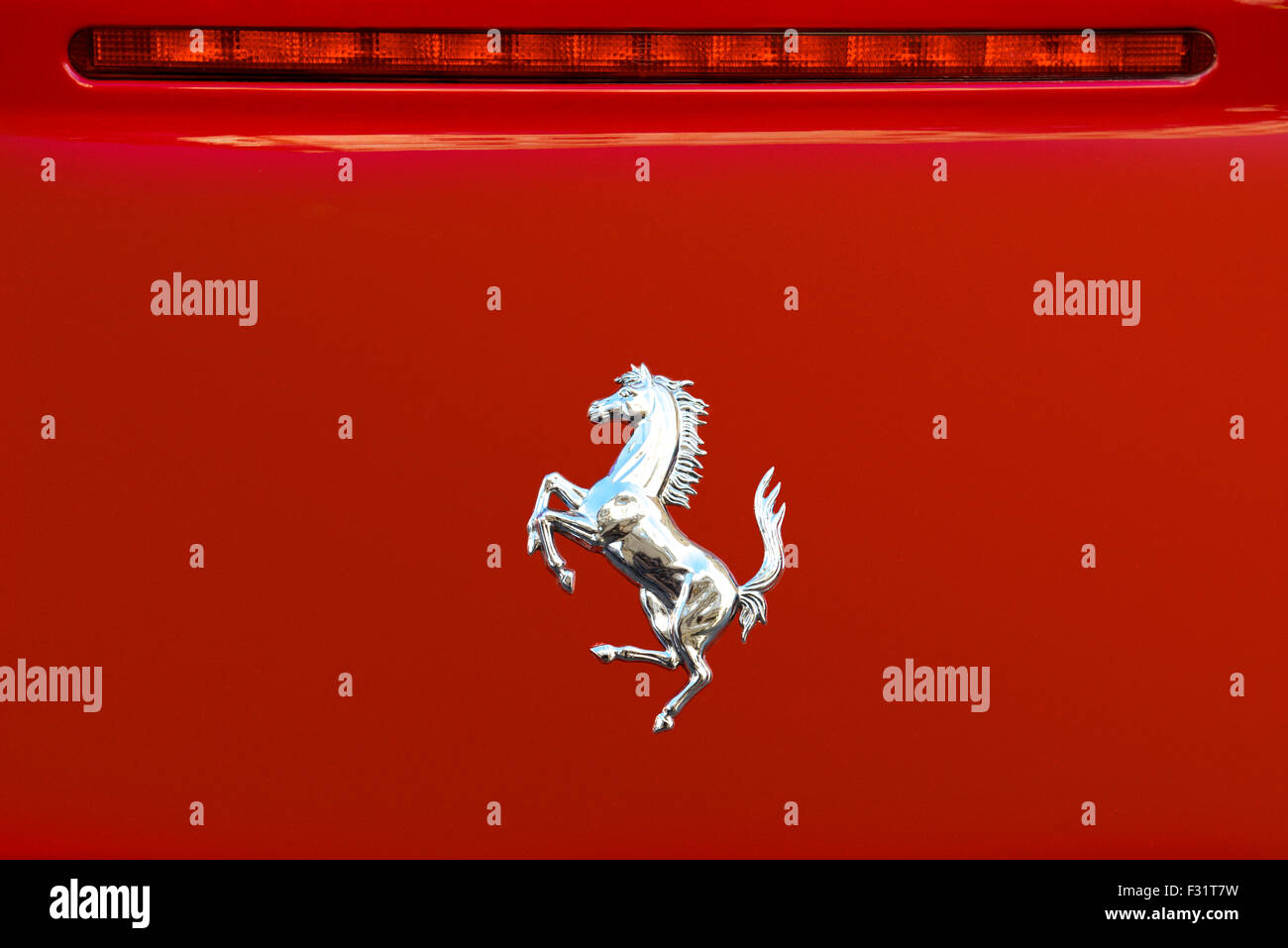 Prague, Czech Republic - June 4, 2015: The Cavallino Rampante, symbol of Ferrari on red luxury car at town boulevard in Prague. Stock Photo