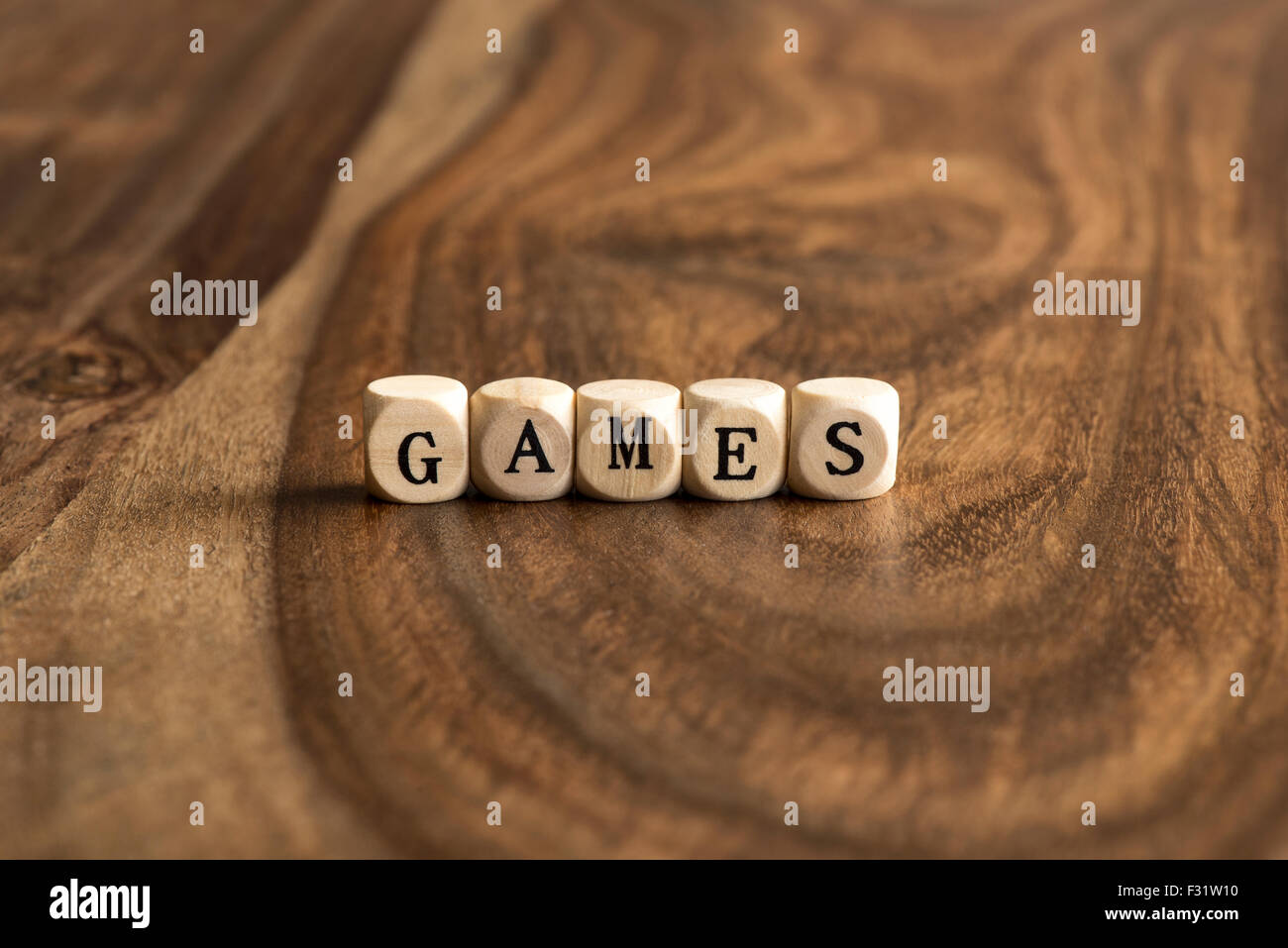 Word GAME made with block wooden letters over the wooden board surface Stock Photo