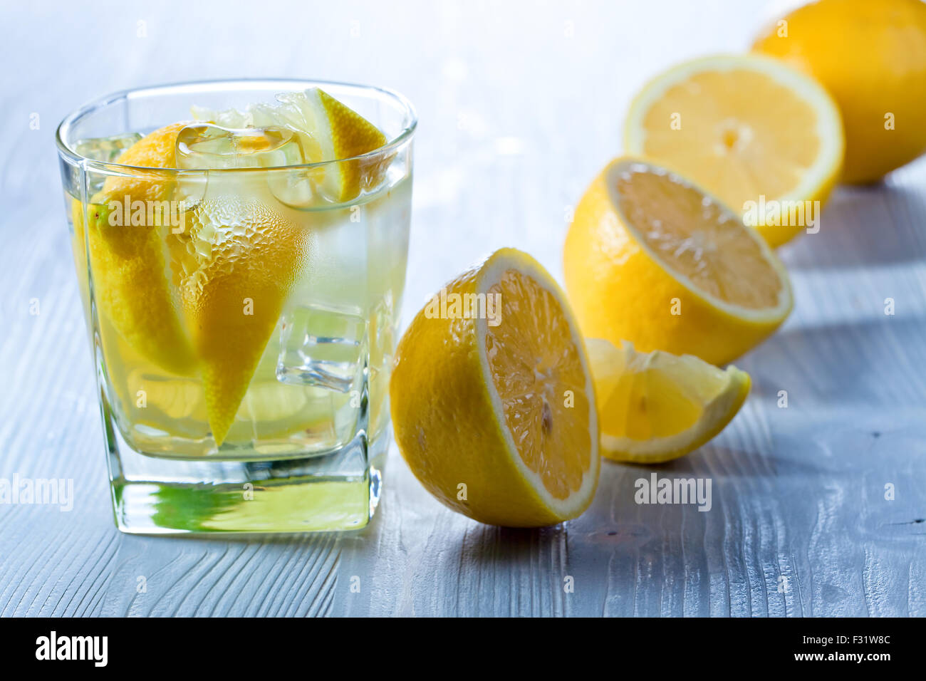 gin and tonic with lemon and ice on wooden table Stock Photo Alamy