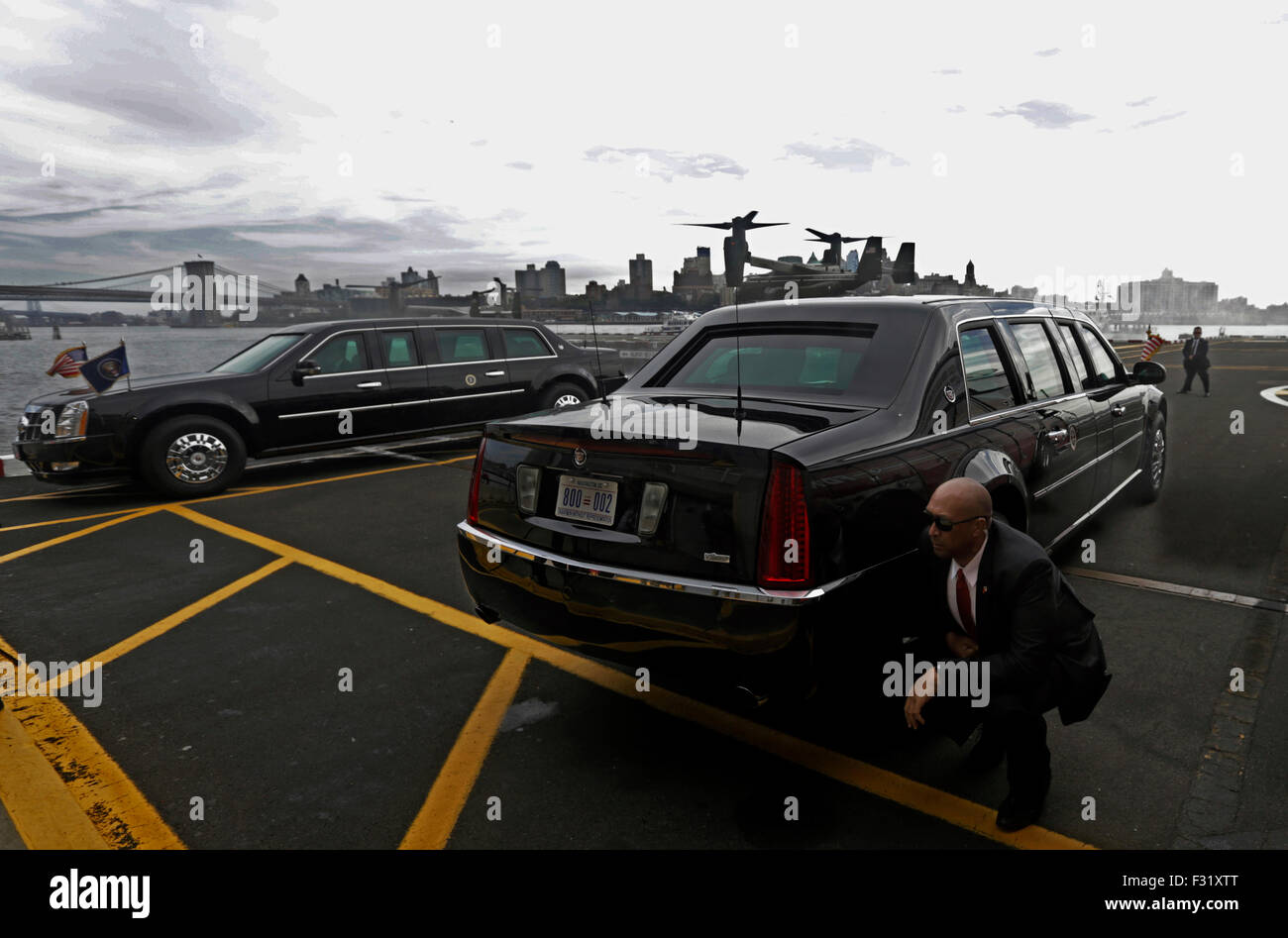 New York, New York, USA. 27th Sep, 2015. A US Secret Service agent (R) kneels down to avoid the rotor wash from the first of four White House helicopters that escort US President Barack Obama from Kennedy airport to lower Manhattan in New York, New York, USA, 27 September 2015. The President will speak at the Sustainable Development Summit today and address the the 70th session of the United Nations General Assembly, General Debate on Monday 28 September 2015. Credit: Peter Foley/Pool via CNP /dpa - NO WIRE SERVICE - Credit:  dpa/Alamy Live News Stock Photo