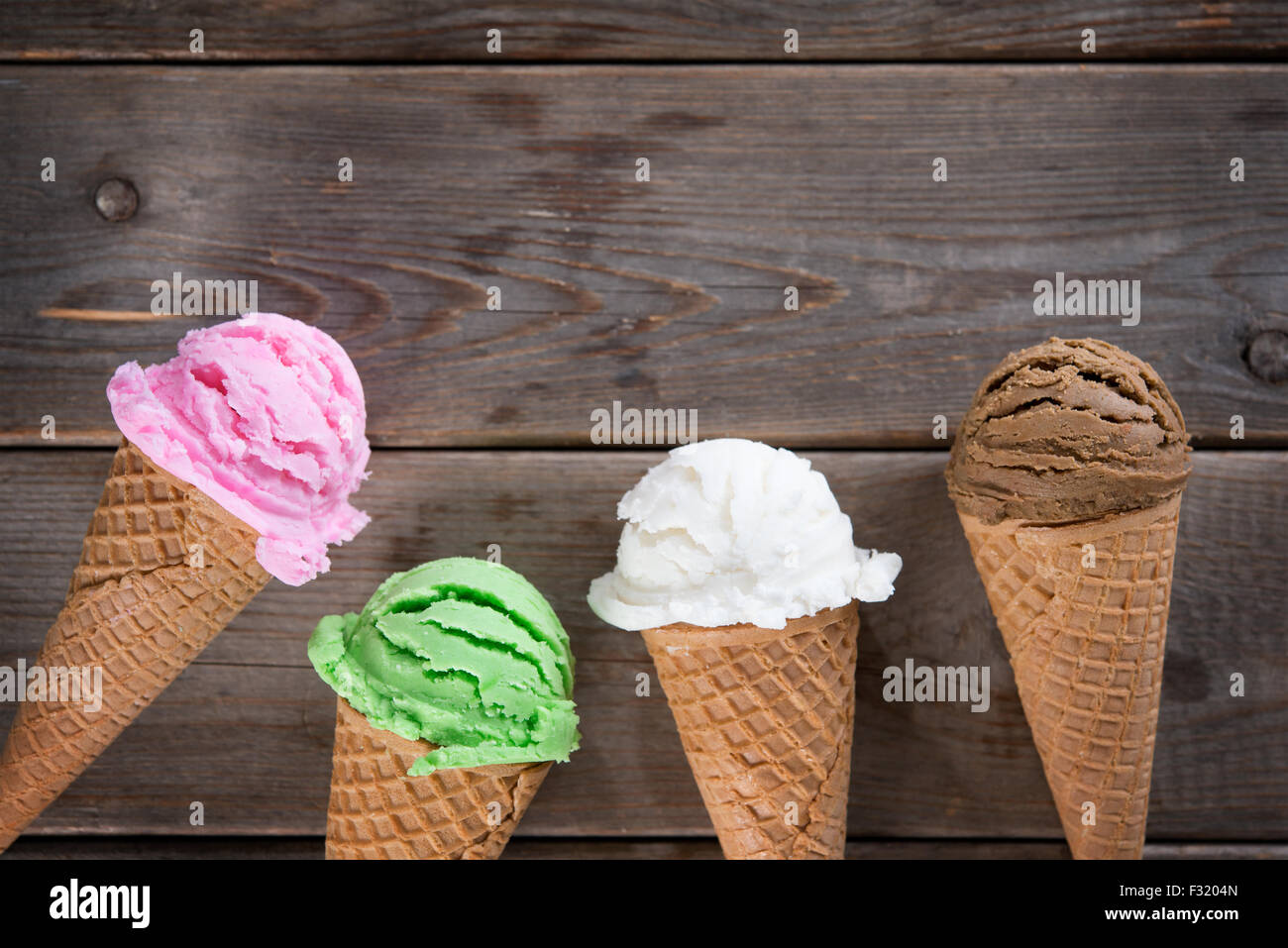 Top view four ice cream cones on old rustic wooden vintage background. Copy space on top. Stock Photo