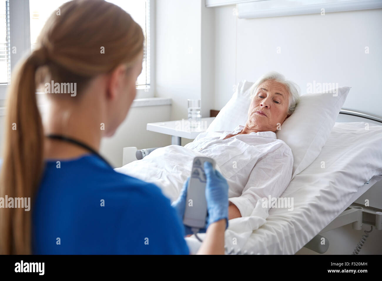 doctor or nurse visiting senior woman at hospital Stock Photo - Alamy