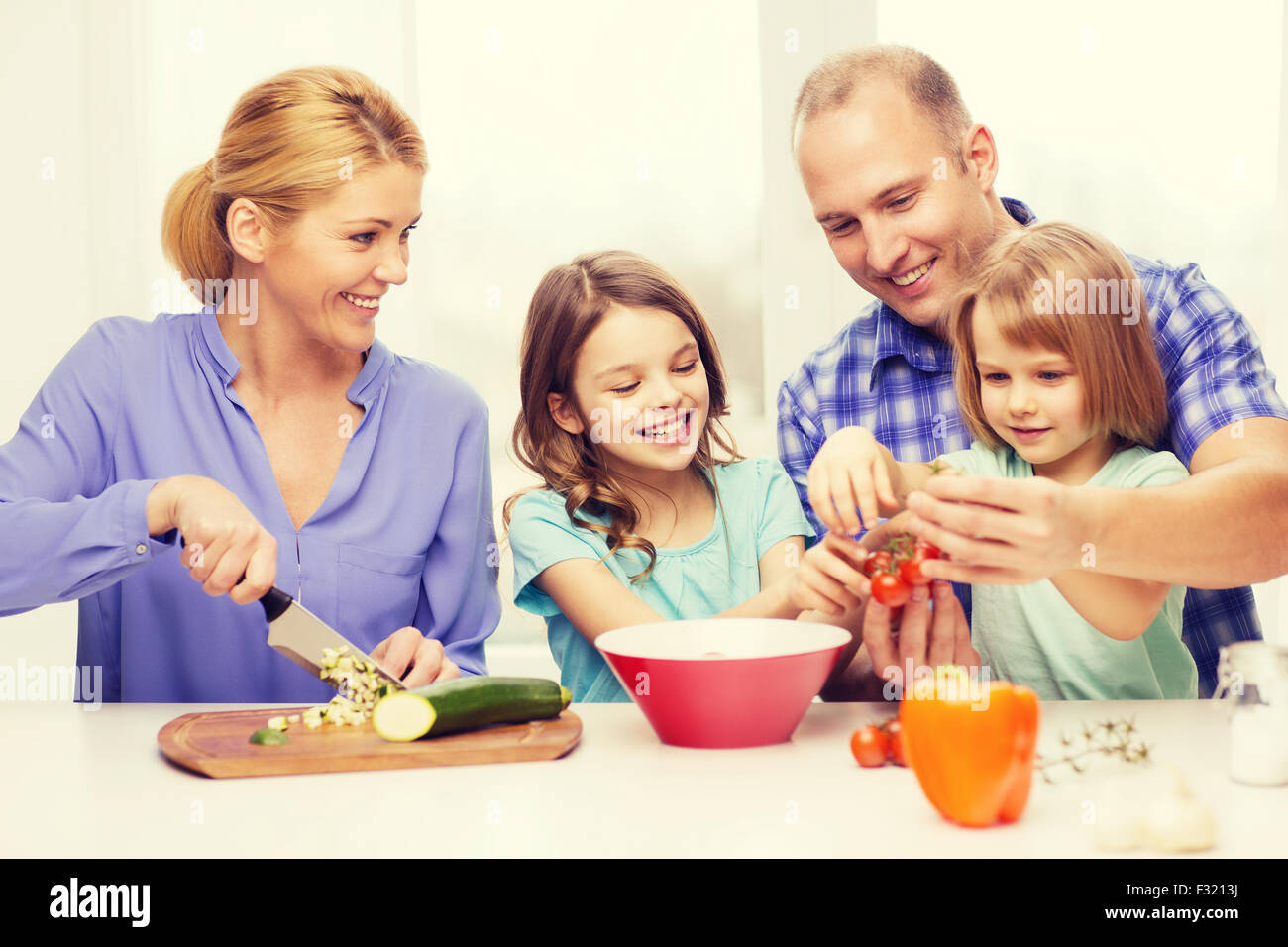 happy family with two kids making dinner at home Stock Photo - Alamy