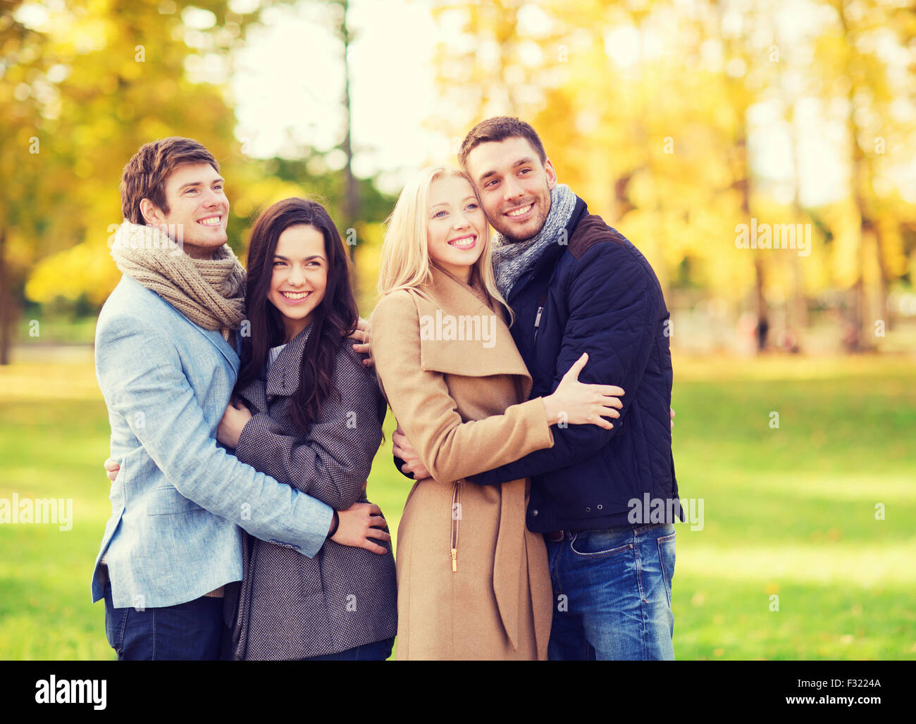 group of smiling men and women in autumn park Stock Photo