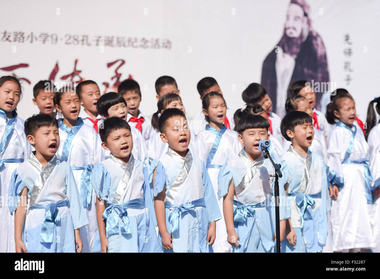 Hefei, China's Anhui province. 28th Sep, 2015. Students of Xiyoulu primary school wearing traditional costumes recite the Analects of Confucius during a ceremony to mark the Chinese philosopher Confucius' 2,566th birth anniversary in Hefei, capital of east China's Anhui province, Sept. 28, 2015. © Zhang Duan/Xinhua/Alamy Live News Stock Photo