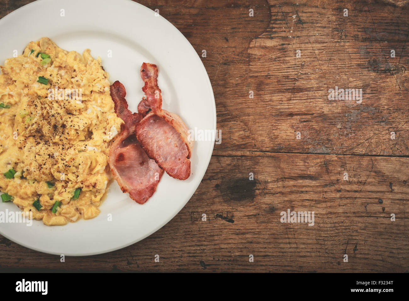 Bacon and scrambled eggs on a white plate Stock Photo - Alamy