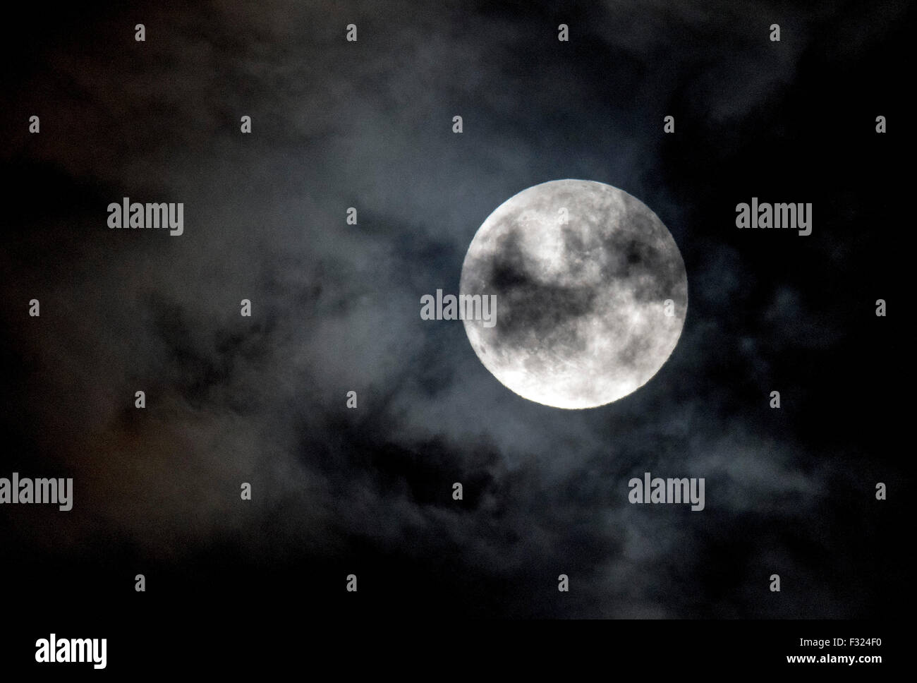 Athens, Greece. 27th Sep, 2015. The Fullmoon is seen rising over the cloudy sky of Athens, Greece, on 27 September 2015. Skywatchers will enjoy a total lunar eclipse at a 'Supermoon' early morning on 28 September, when the Moon will make its closest approach to the Earth and passes into the Earth's shadow. Credit:  Elias Verdi/ Alamy Live News Stock Photo