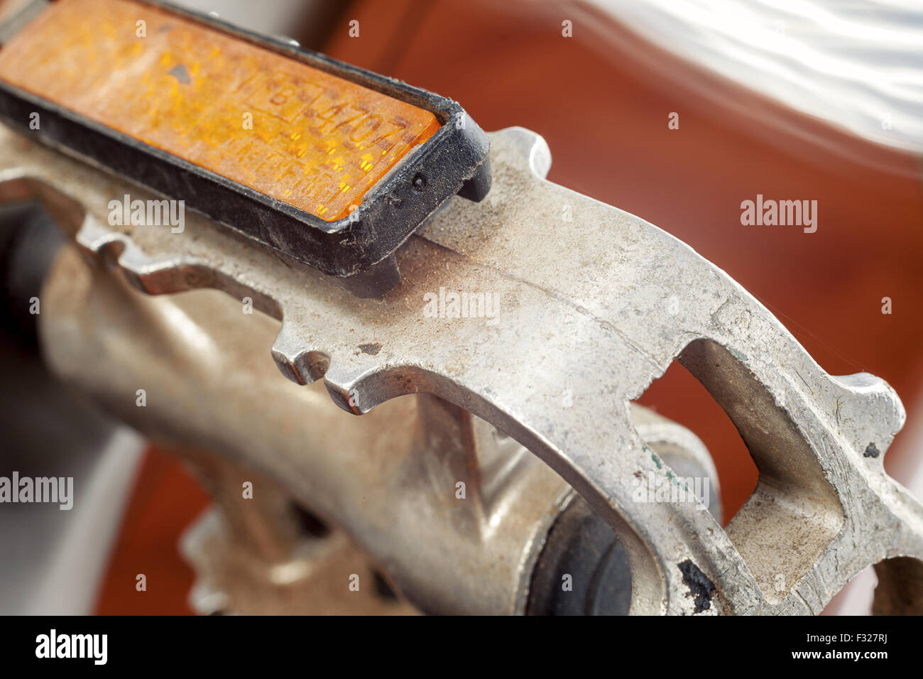 Part of a bicycle, detail of a pedal, bright orange part called cat eye. Stock Photo