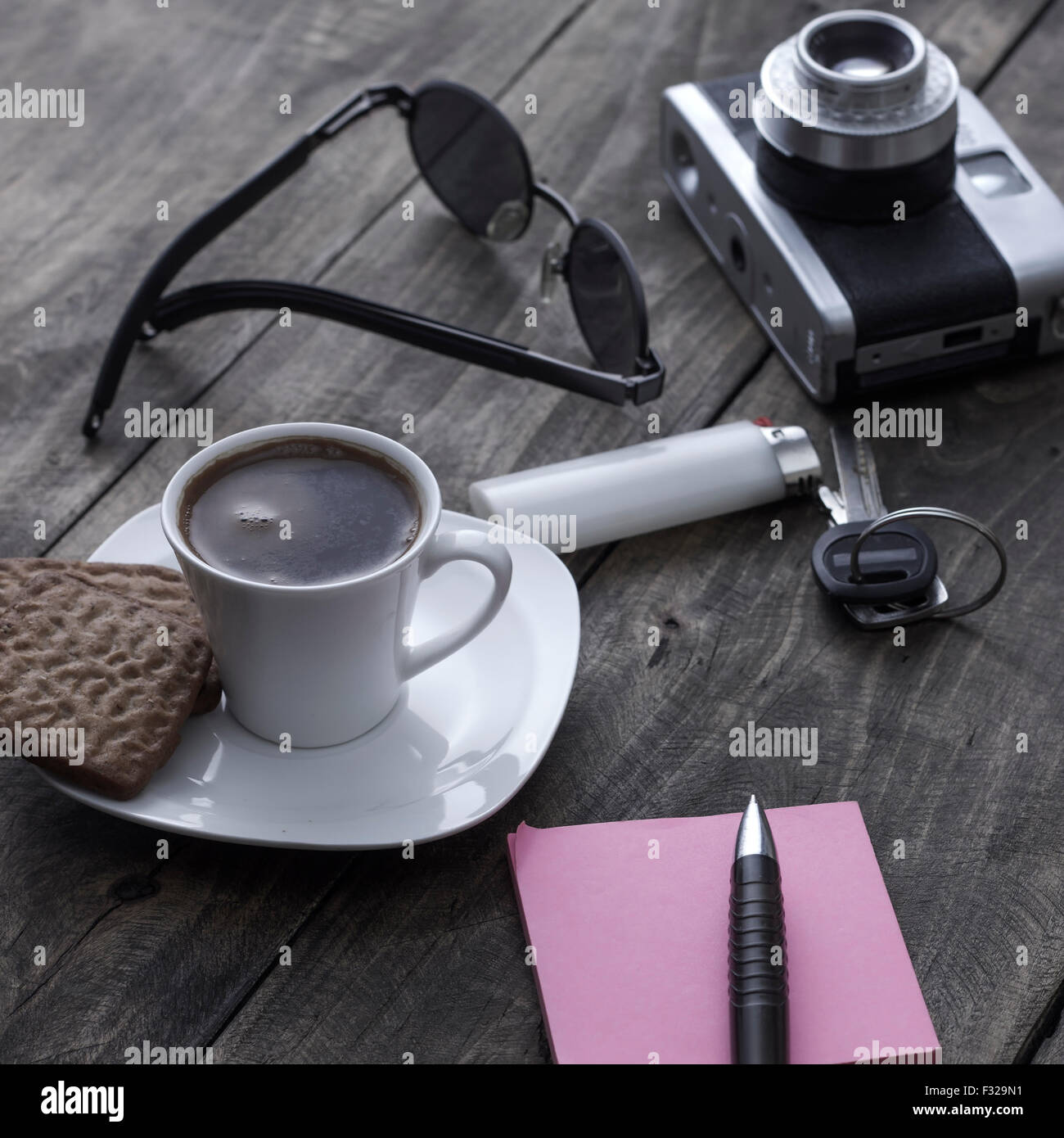 Analogue photo camera on a table with coffee and paper notes Stock Photo